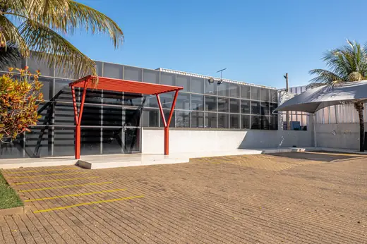 Entrada principal da Oximed com estrutura metálica vermelha e fachada de vidro
